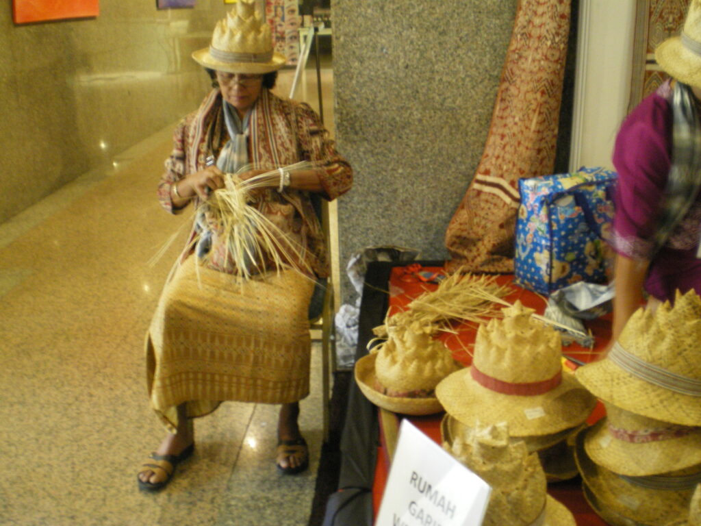 Photo prise de lors de l'ISEND à Kuching, Sarawak, Bornéo, Malaisie, ici une des artisane de Rumah Gari tisse un chapeau typique